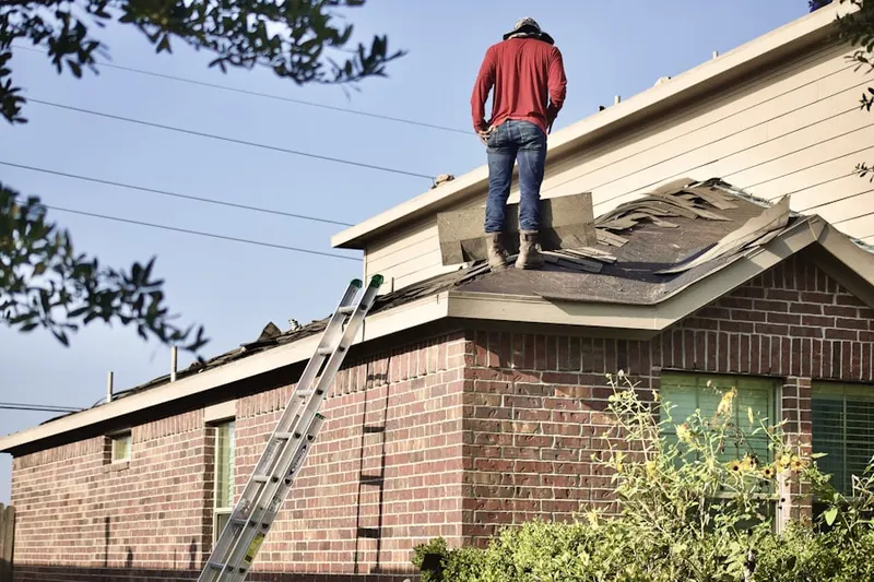 Professional roofer working on a residential roof in Chateaugay